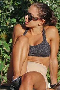 Tanned fitness woman showing off her toned physique & amazing butt