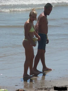 Sexy blonde on the beach in a yellow thong bikini
