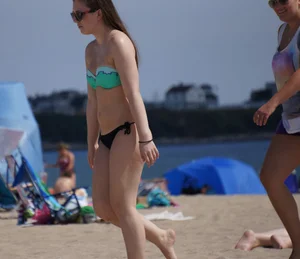 Sexy beach brunette in teal top and black bottom bikini