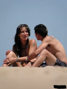 Topless lady on the beach in a gold thong with a nice ass