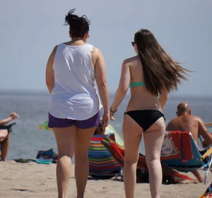 Sexy beach brunette in teal top and black bottom bikini