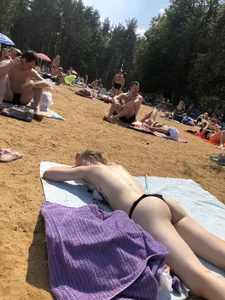 Topless Skinny Girl With Very Pale Skin Lying on a Beach on Her Tummy With Slightly Spread Legs Creepshots Gallery
