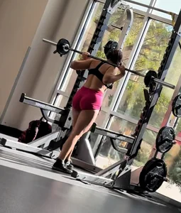 Bend over at gym in red shorts