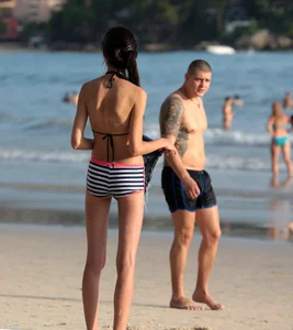 Skinny small boobed girl in a bikini on the beach with her friend