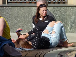 Girl in Torn Jeans Lying on the City Street Candid