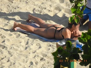 Big booty beach babe laying out in thong