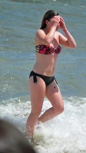 Cute beach girl in little bikini in the water