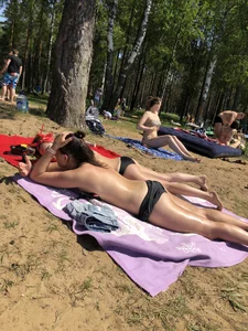 Skinny Girl in Swimsuit Lying on the Lake Beacg Topless and Bending Over
