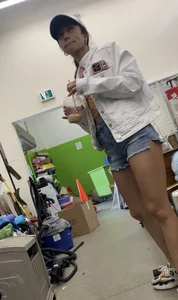 Tight bum hanging out of jean shorts in thrift shop