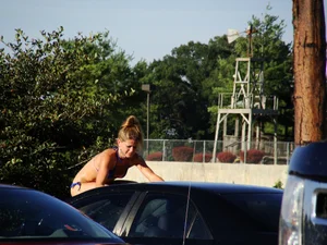 Group of cute girls at a car wash in bikinis and shorts