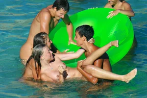 FKK Nudists playing in the water with floater