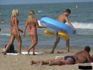 Sexy mom and daughter in red thongs at the beach