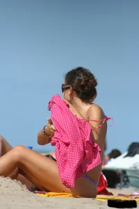 2 topless girls at the beach in thongs