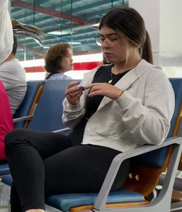 Girl in leggings sitting with crossed legs at a station