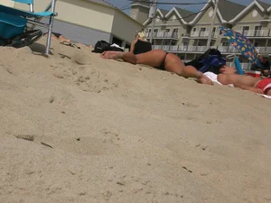 Milf laying out on a beach in Maine in her little thong