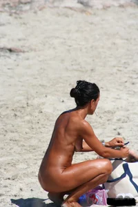 Smoking milf at a nude beach with a hairy pussy