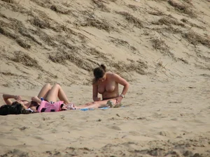 Topless beach girl with nice titties with her friend in a bikini