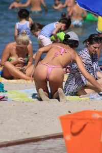 Sexy milf in pink thong bikini on the beach