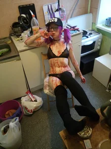 Skinny Cosplayer Girl with Purple Hair Wearing Glasses in Knee Socks and Lingerie Covered in Fake Blood Sitting in the Kitchen with Her Legs on Table