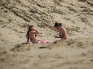 Topless beach girl with nice titties with her friend in a bikini