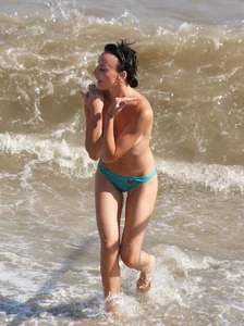 Cute brunette lady topless at the beach with awesome tits