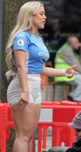 Curvy blonde girl in soccer / football kit & shorts poses for photos