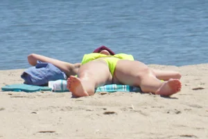 Sexy ass blonde milf on the beach in a thong with cameltoe and bending over