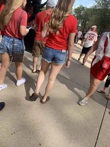 Bunch of girls in various outfits at a Cardinals baseball game