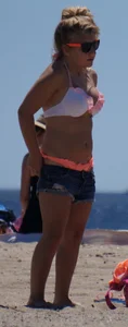 Thick blonde girl in an orange bikini on the beach