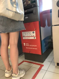 Young Candid Girl With Slim Pale Legs In a Denim Skirt Waiting in the Queue