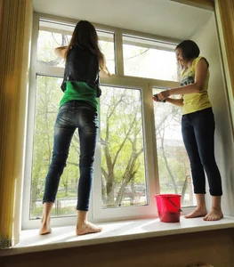 Barefoot Teens in Tight Jeans Standing on a Windowsill Cleaning a Window