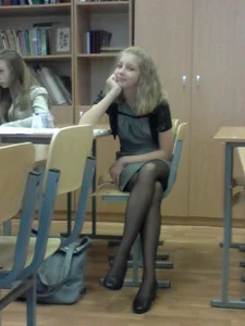 Cute and skinny blonde college teen wearing a skirt and black pantyhose in class