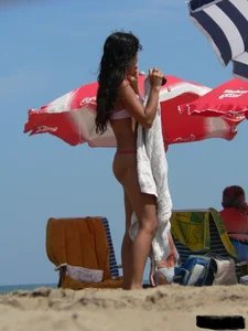 Hot brunette ethnic girl on the beach in a pink thong bikini