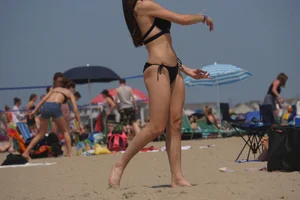 Sexy brunette in bikini playing football on the beach