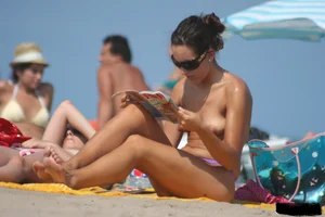 2 topless girls at the beach in thongs