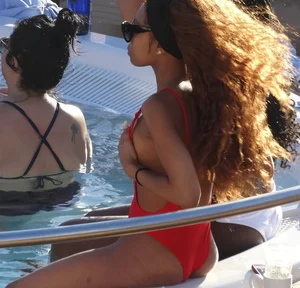 Sexy black girl in red swimsuit at the pool with side boob and a nice ass