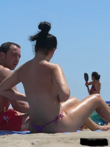 Purple thong topless lady on the beach gets oiled up by her husband