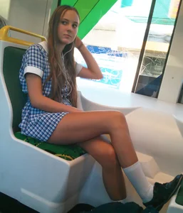 Girl in a dress sitting in a public train