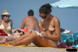 2 topless girls at the beach in thongs