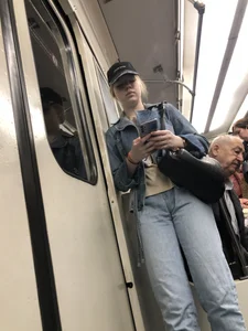 Cute girl in jeans standing in a subway train