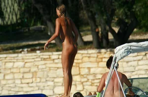 Two sexy nude beach friends getting some sun