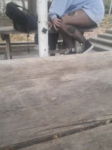 College teen in ripped pantyhose sitting outside