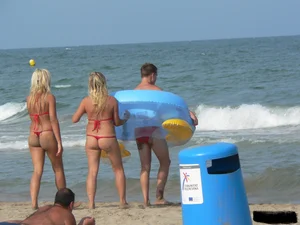 Sexy mom and daughter in red thongs at the beach