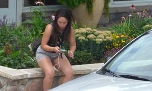 Thick brunette listening to music in shorts