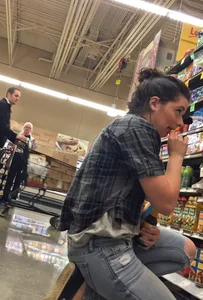 Sexy brunette grocery shopping in tight jeans