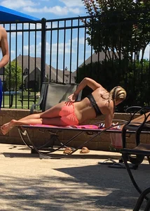 Blonde at the pool and laying out in peach and black bikini combo