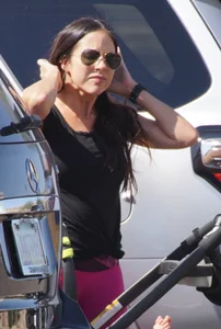 Milf brunette in purplish-pink leggings looking sexy in the parking lot
