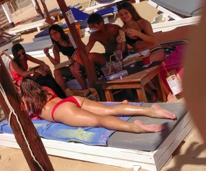 Thick brunette on the beach with friends in red bikini