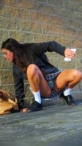 Girl Sitting on the Floor in a Skirt Revealing Panties While Standing Up