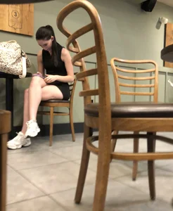 Hot candid girl wearing tight shorts sitting in a coffeeshop, hot legs